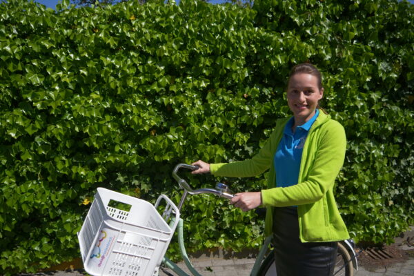 eBirds & Zomerzorg - vrouw staat met een fiets aan de hand